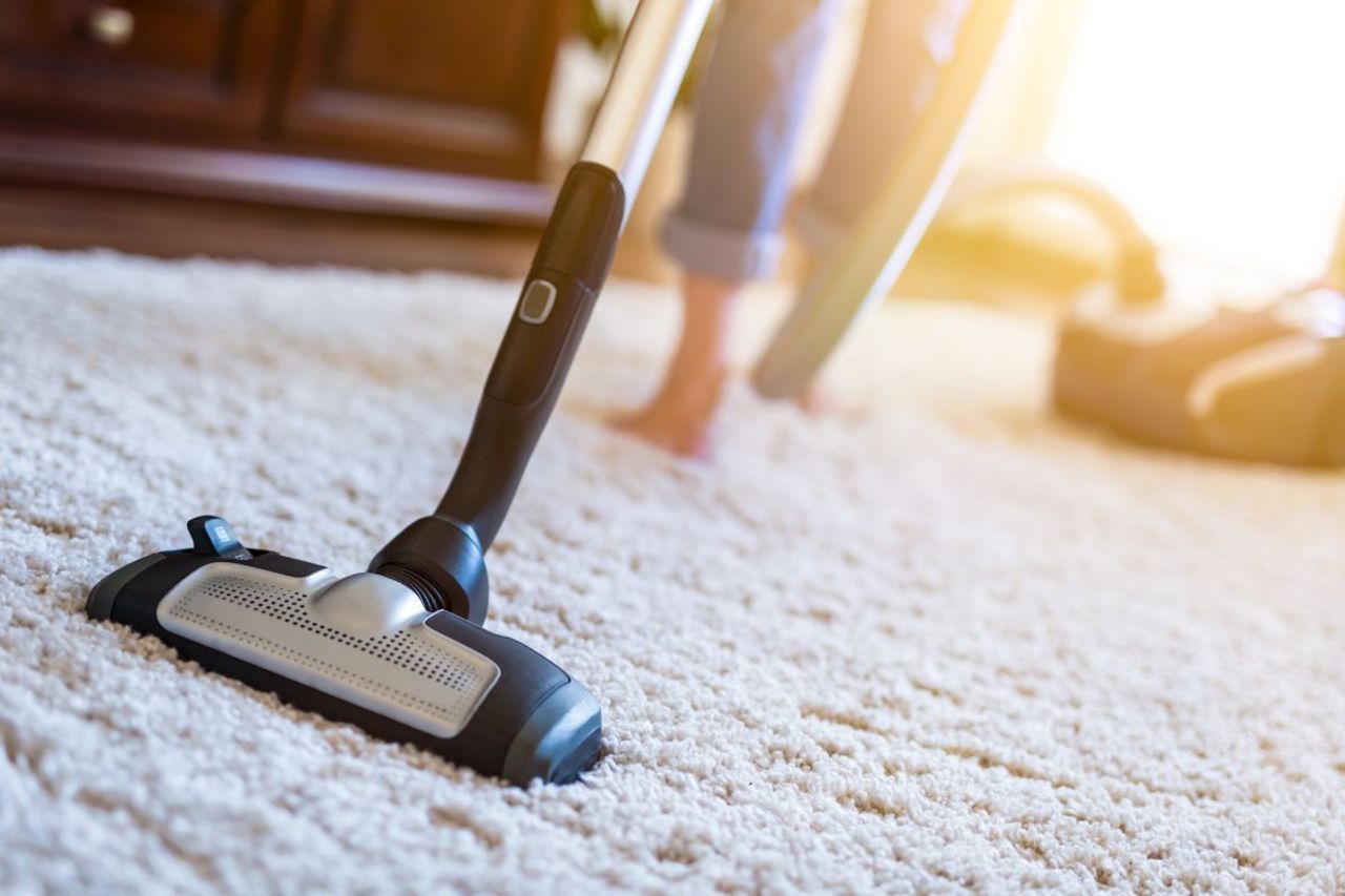 Langfloorteppich wird mit Staubsauger abgesaugt.
