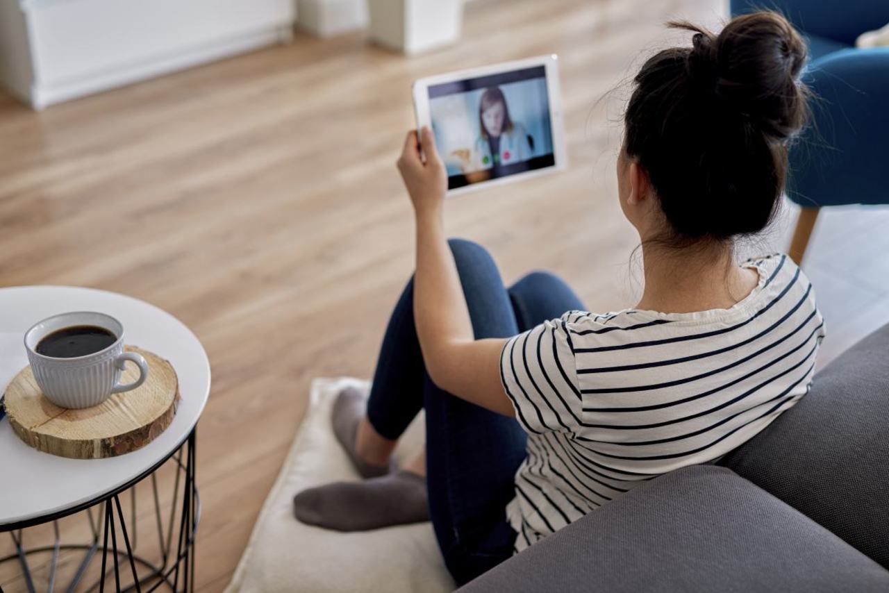 Junge Frau hat Sprechstunde online am Tablet mit Ärztin.