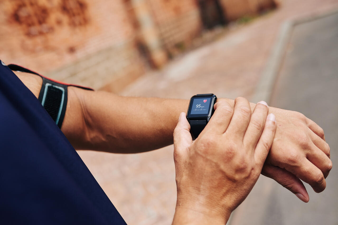 Mann misst seinen Puls mit einer Smartwatch.