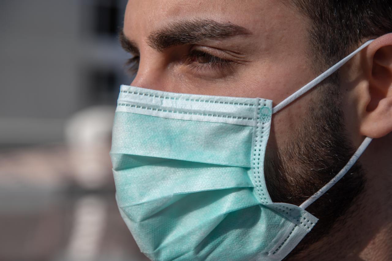 Mann trägt OP-Maske als medizinischen Mundschutz während der Corona-Pandemie.