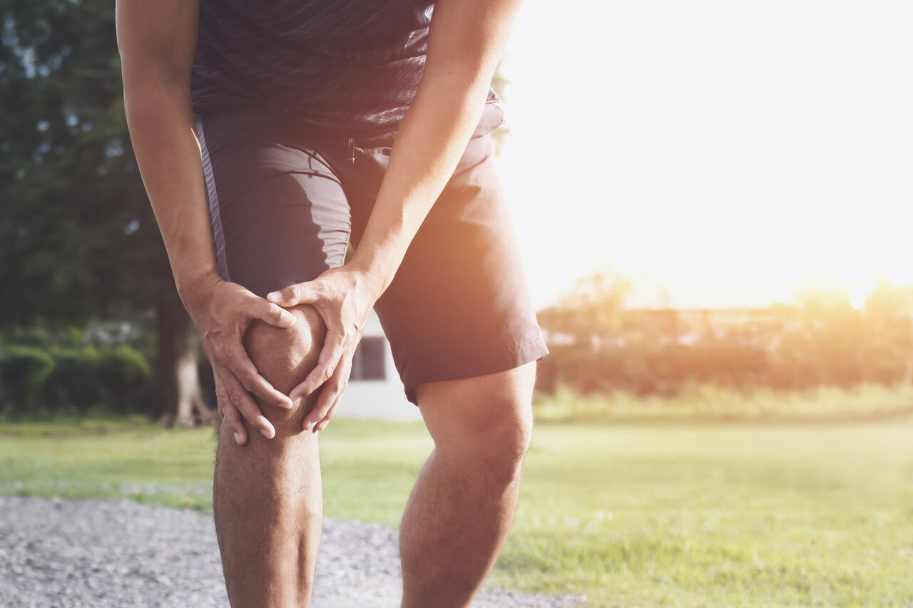 Ein Jogger fasst sich an das schmerzende Kniegelenk.