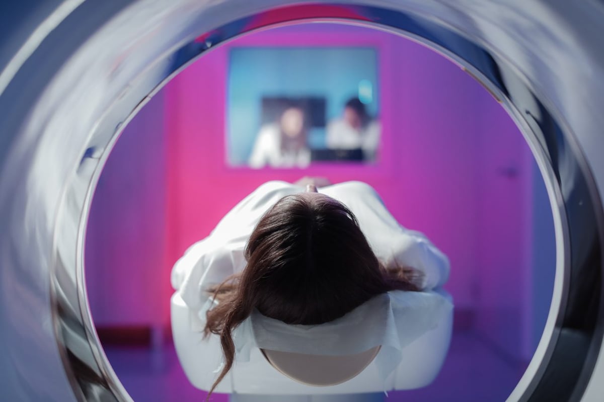 Eine Patientin liegt auf dem Gerätetisch und wird in den Tomographen eingefahren.