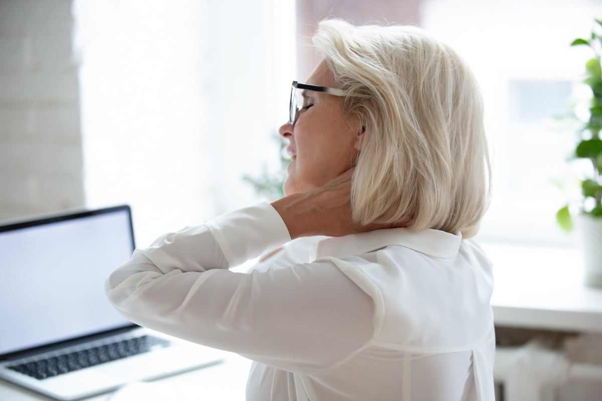 Eine Frau mit Fibromyalgie (Fibromyalgie-Syndrom, Faser-Muskel-Schmerz FMS) hat Schmerzen im Nacken.
