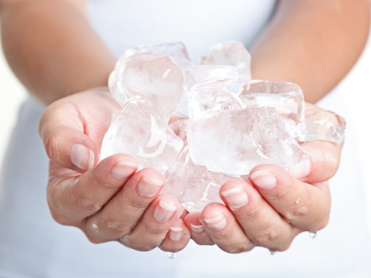 Viele Eiswürfel werden in Händen gehalten.