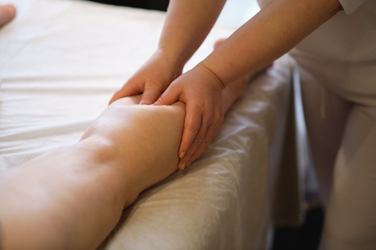 Eine Patientin erhält eine Lymphdrainage am Bein.