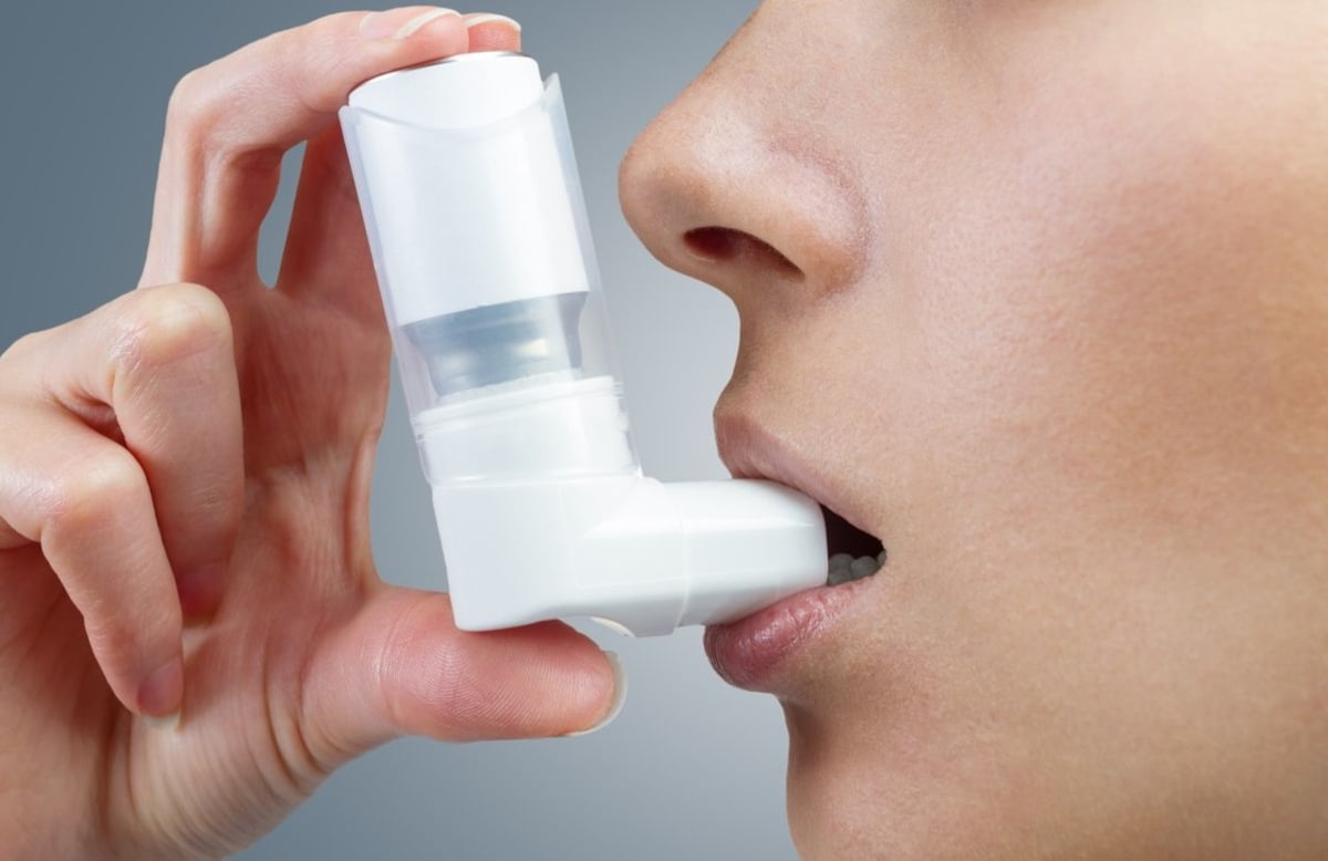 Frau verwendet Asthma-Spray mit Inhalator.