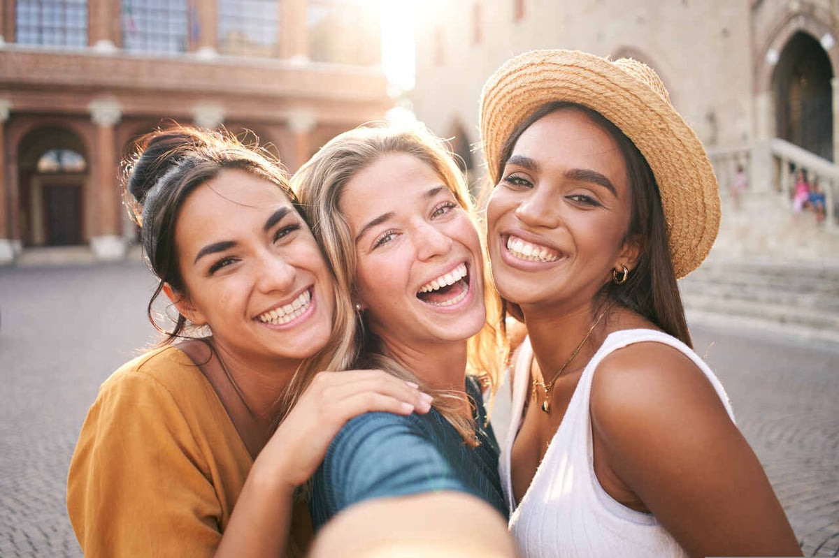 Drei Frauen lachen in die Kamera.
