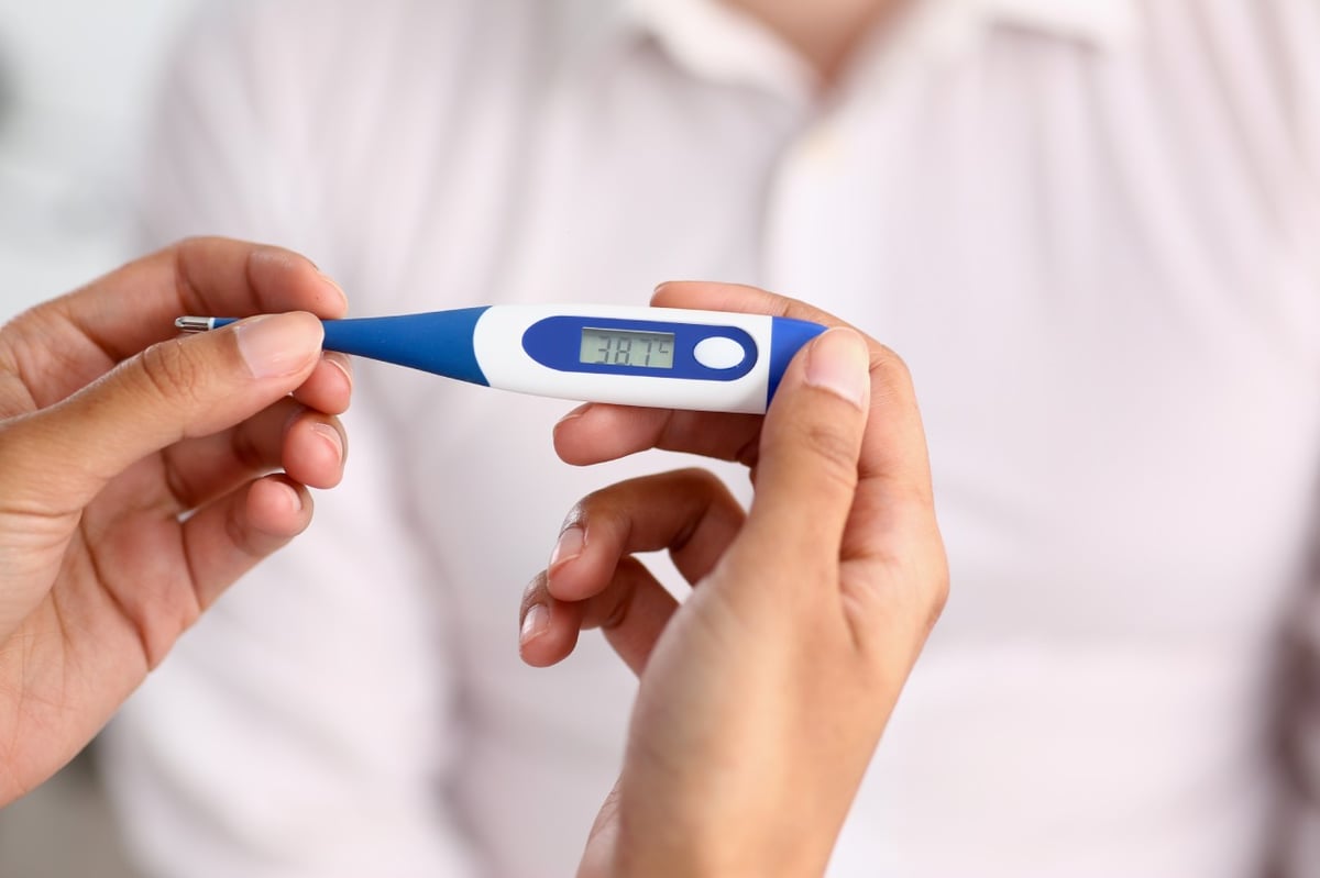 Ein Fieberthermometer zeigt 38,7 °C an.