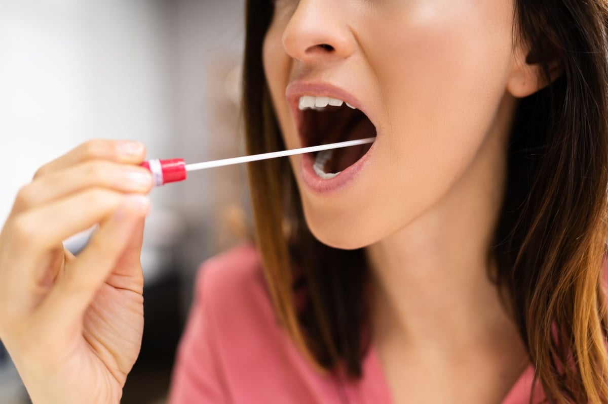 Frau macht mit Stäbchen einen Wangenabstrich. Aus dem biologischen Material kann eine Typisierung für Stammzellspenden erfolgen.