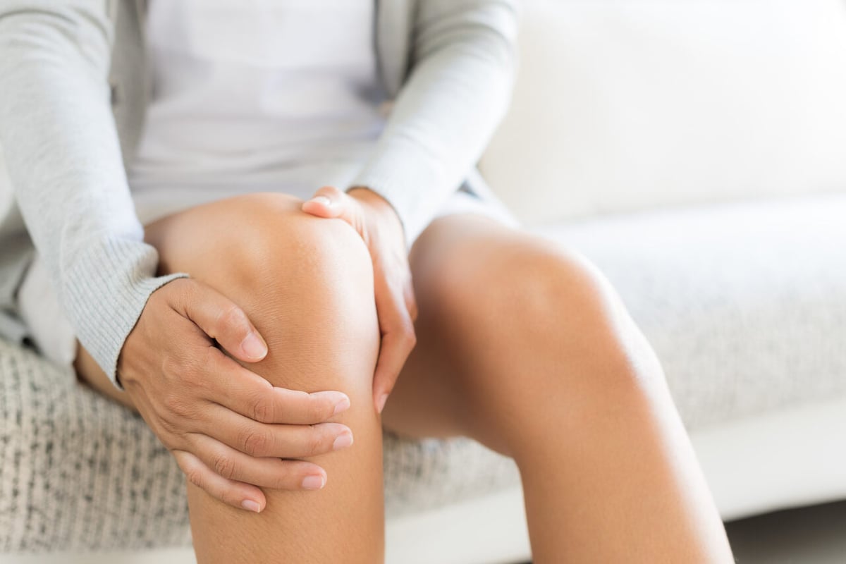 Frau massiert ihr schmerzendes Knie.