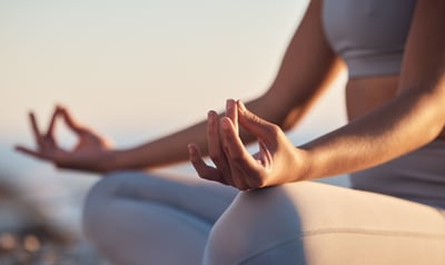 Frau im Schneidersitz meditiert.