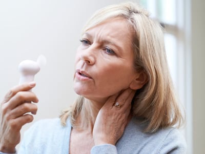 Hormonersatztherapie (HET). Frau mit Hitzewallungen hält Ventilator.