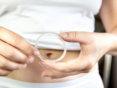 Eine Frau hält einen Verhütungsring (Vaginalring) in ihren Händen.
