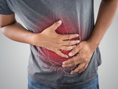Person-haelt-sich-den-Bauch-mit-beiden-Haenden
