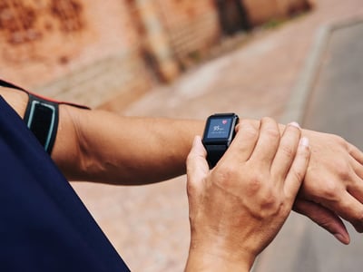 Mann misst seinen Puls mit einer Smartwatch.