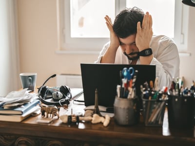 Mann mit Burnout ist verzweifelt im Büro oder Homeoffice.