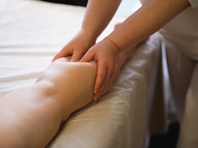 Eine Patientin erhält eine Lymphdrainage am Bein.