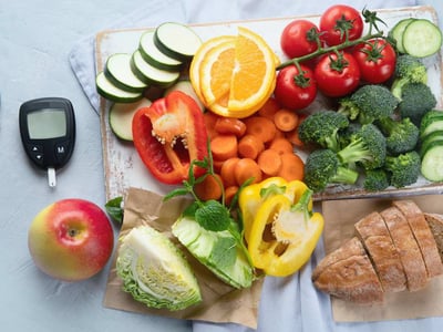 Ernährung bei Diabetes, gesunde Lebensmittel neben Blutzuckermessgerät.