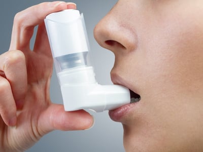 Frau verwendet Asthma-Spray mit Inhalator.