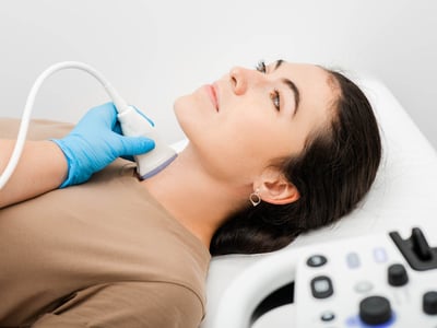 Eine Frau wird per Ultraschall an der Schilddrüse untersucht.

