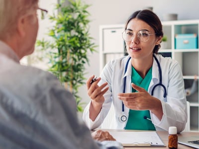 Eine junge Ärztin führt ein Gespräch mit einem Patienten.