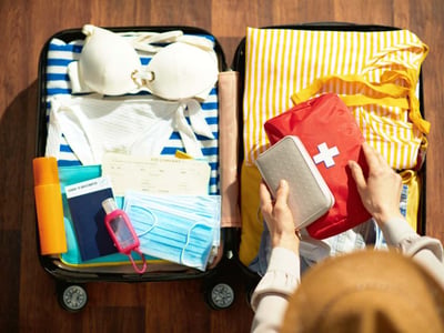 Koffer für den Urlaub packen. Reiseapotheke nicht vergessen.