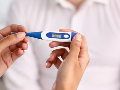Ein Fieberthermometer zeigt 38,7 °C an.