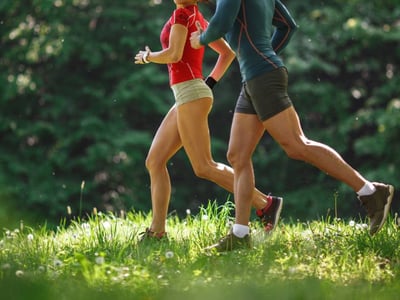 Junges paar joggt im Frühling in der Natur.