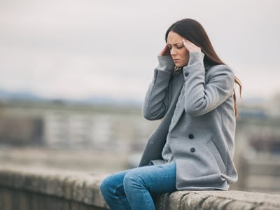 Junge Frau hat Kopfschmerzen durch Wetterumschwung.