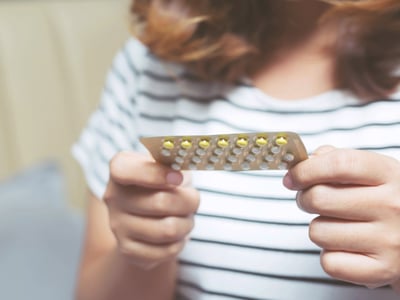 Eine Frau hält eine Packung der Antibabypille in der Hand.