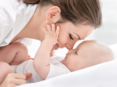 Junge Mutter kuschelt mit ihrem Baby.