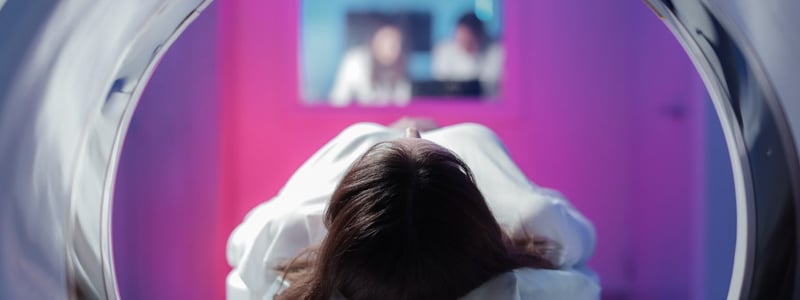 Eine Patientin liegt auf dem Gerätetisch und wird in den Tomographen eingefahren.