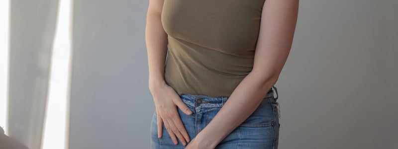 Frau hält eine Hand in ihren Intimbereich.
