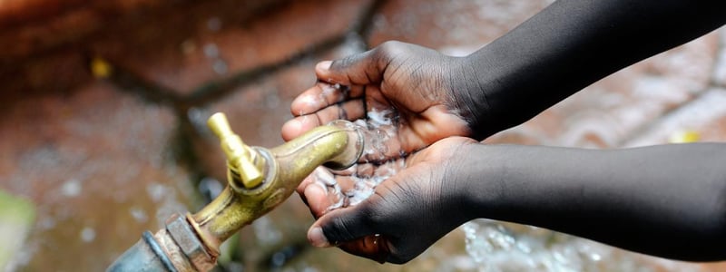 Kinderhände sammeln Wasser zum Trinken.