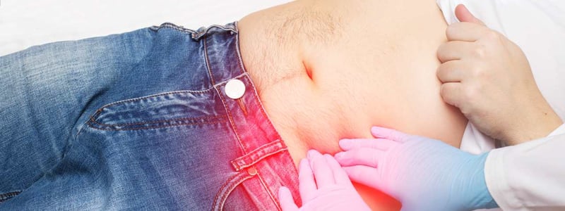 Arzt untersucht Patient durch Palpation des linken Unterbauchs 