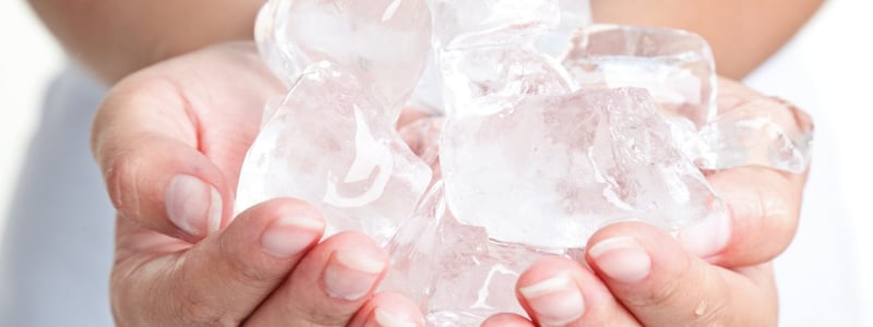 Viele Eiswürfel werden in Händen gehalten.