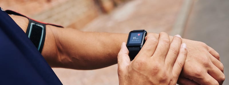 Mann misst seinen Puls mit einer Smartwatch.