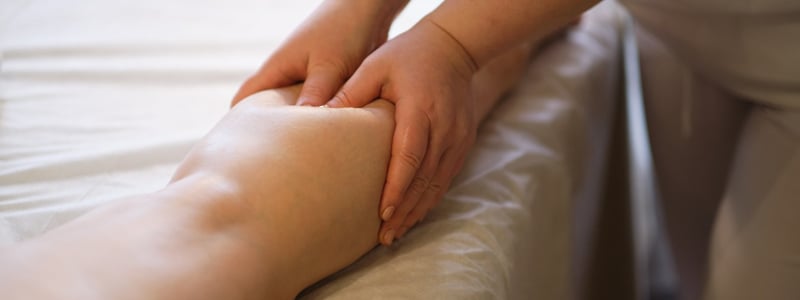 Eine Patientin erhält eine Lymphdrainage am Bein.