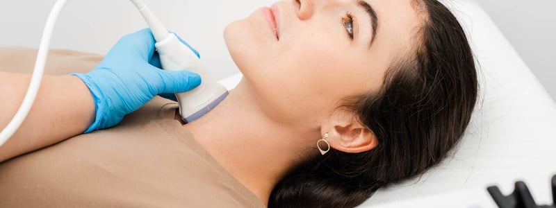 Eine Frau wird per Ultraschall an der Schilddrüse untersucht.

