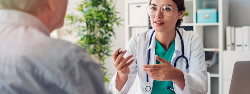 Eine junge Ärztin führt ein Gespräch mit einem Patienten.