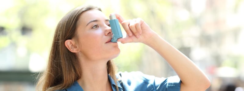 Eine Frau hält einen Asthma-Inhalator.