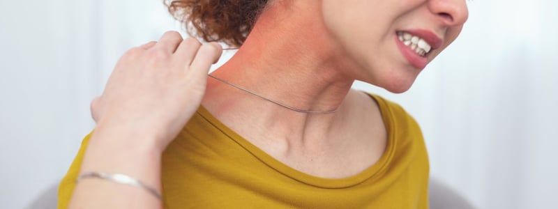Junge Frau reagiert allergisch auf Kette. Schmuck mit Nickel kann Kontaktekzeme auslösen.