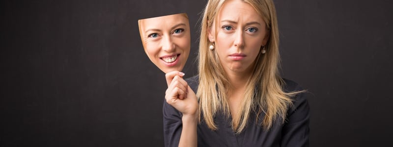 Darstellung von Depression: Traurige Frau hat eine glückliche Maske.