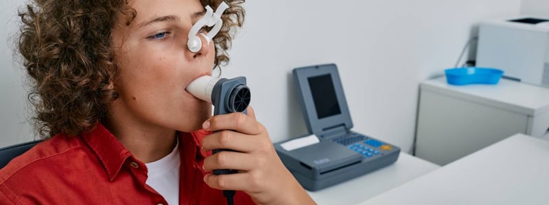 Ein Junge macht in einer Arztpraxis einen Lungenfunktionstest mittels Spirometrie.