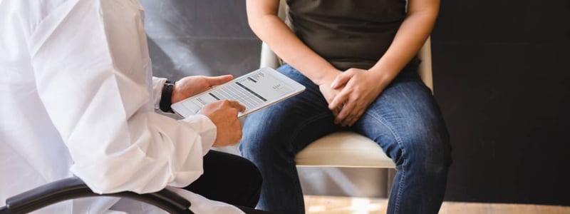 Mann auf Sofa hält sich den Schritt